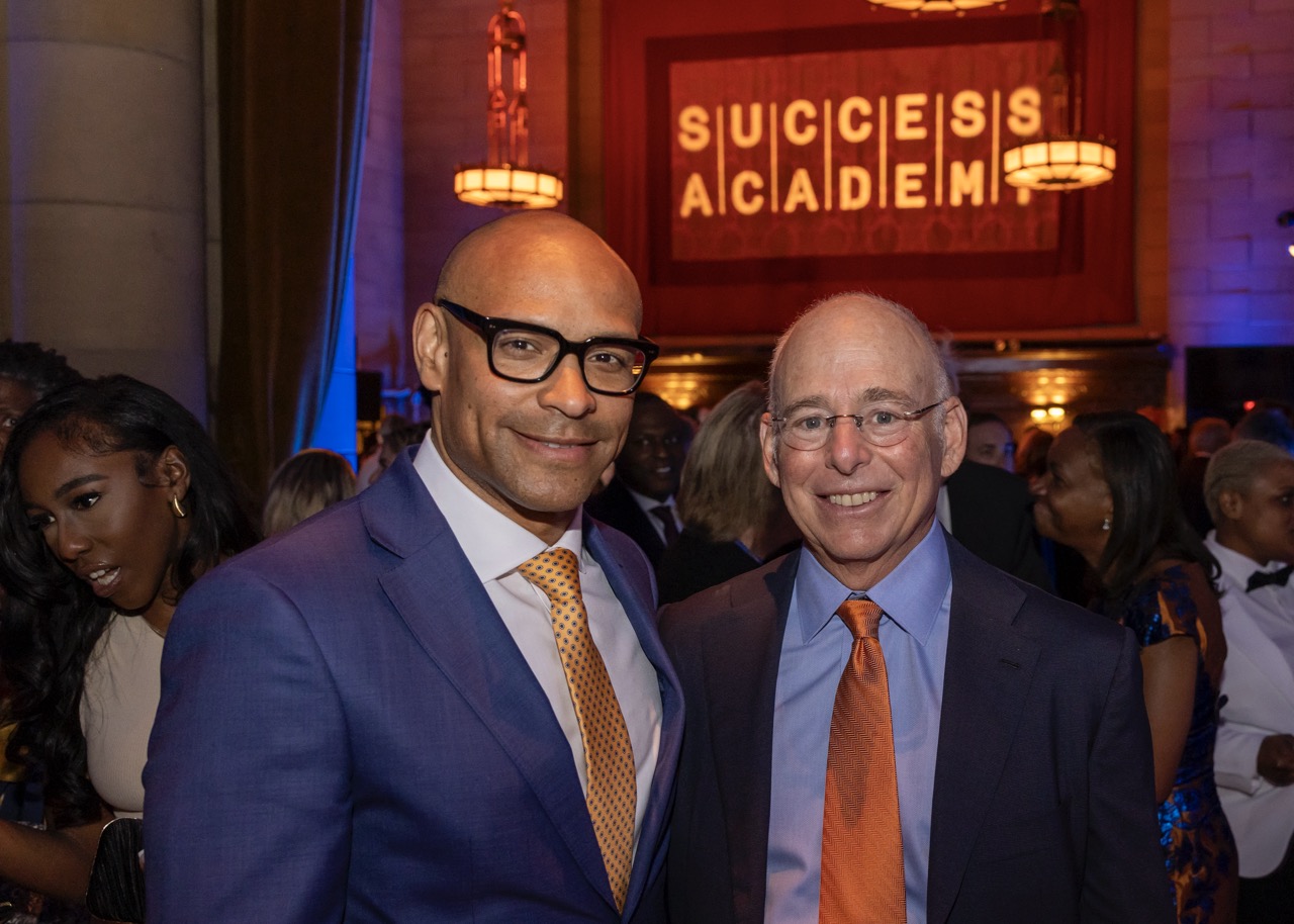 Two men smiling, posing at an event, 